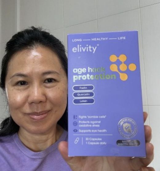 A smiling verified buyer in Singapore holding up her box of age hack protection.